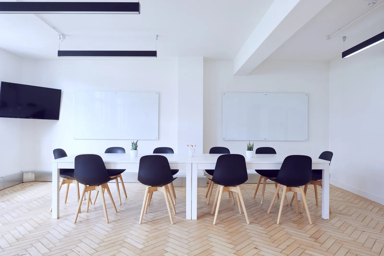 A bright meeting room with a long white table and chairs