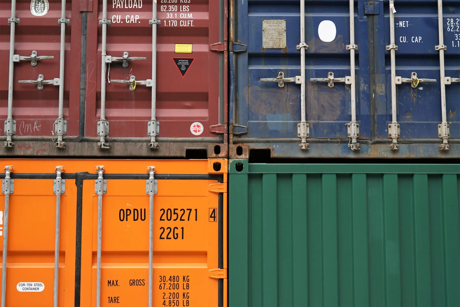 Close-up of the doors of red, blue, orange and green freight containers