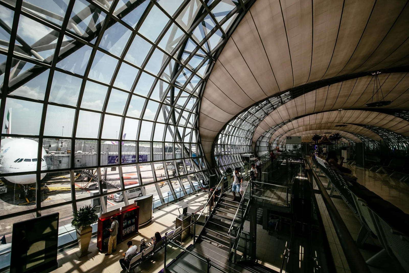 The glass-roofed interior of a large airport terminal