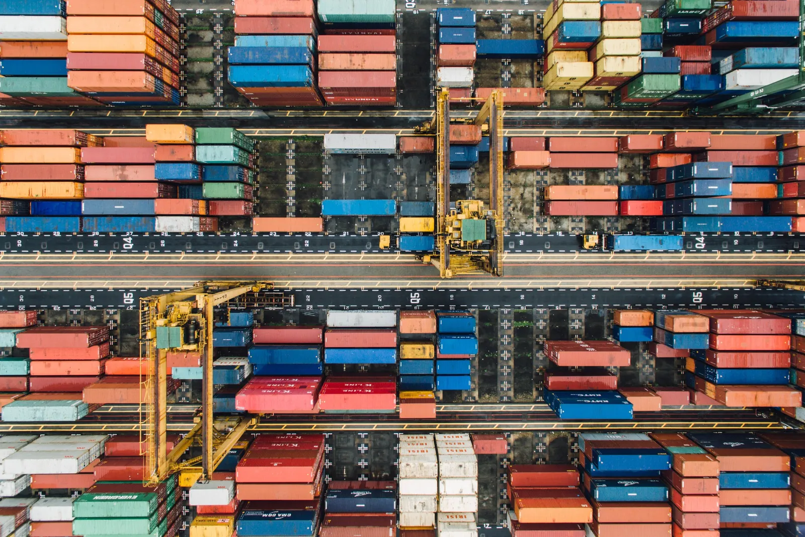 Aerial view of a container terminal with stacked containers and cranes