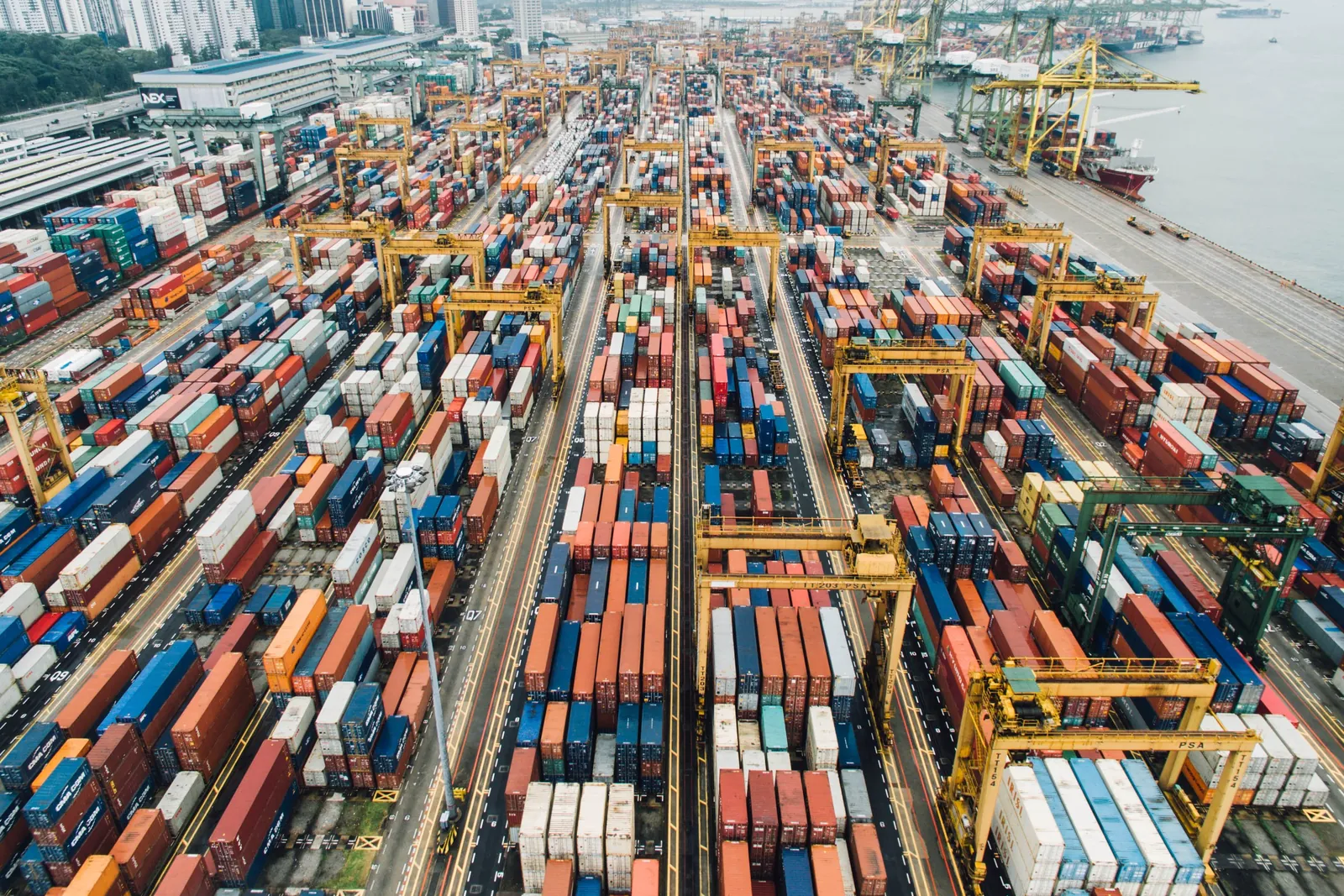 A container port seen from above, with rows of containers and gantry cranes